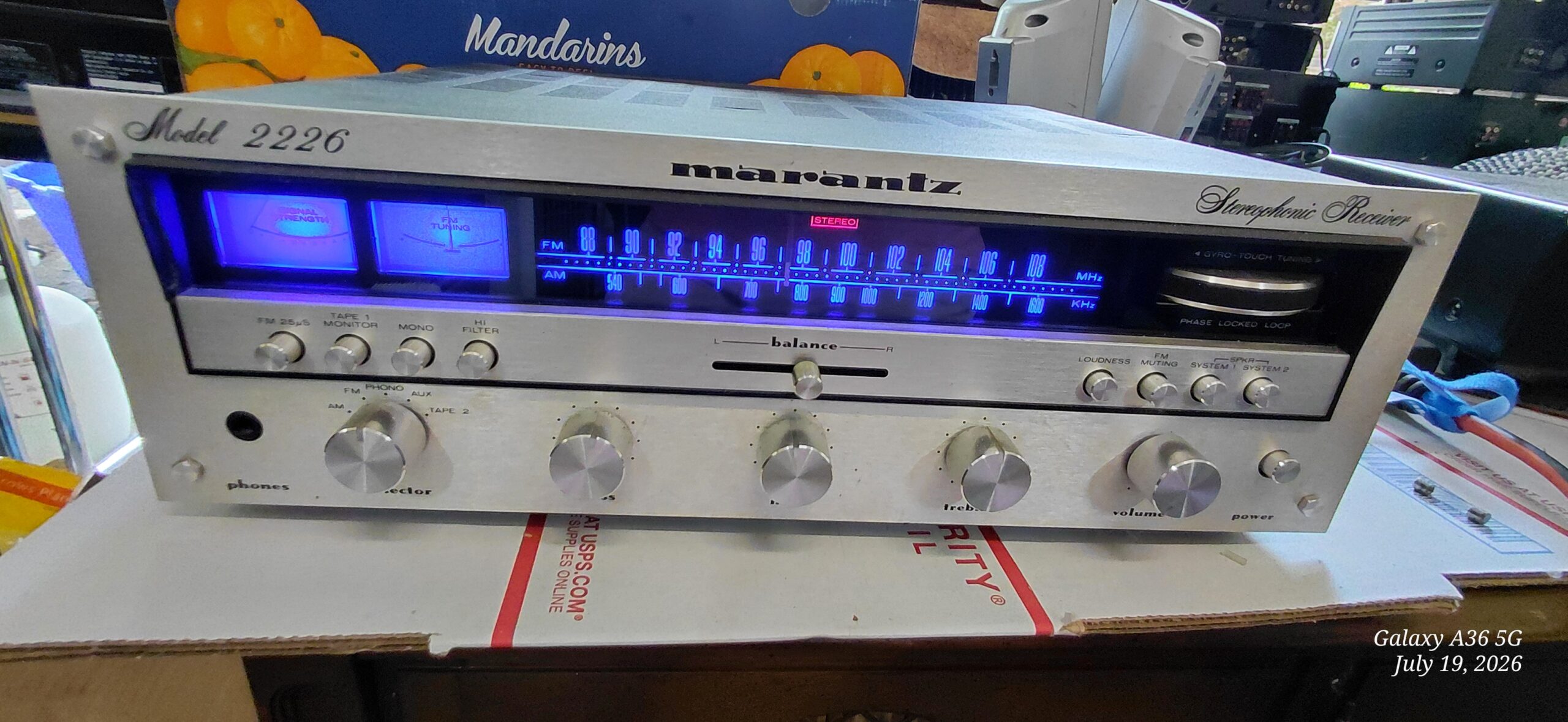 Vintage Marantz Model 2226 stereo receiver with blue-lit signal strength and FM tuning meters, on a repair bench